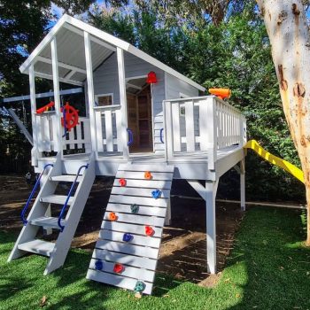 Elavated cubby house with large verandah swings and slide