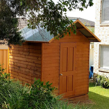 small timber shed stained in deep cedar color